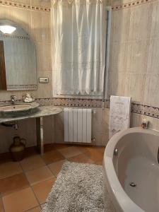 a bathroom with a tub and a sink and a mirror at CASA SEBASTIANA SUITE in Losar de la Vera