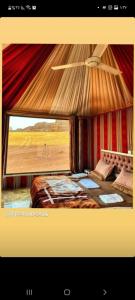 a bedroom with a bed and a large window at Star Wars Wadi Rum in Wadi Rum