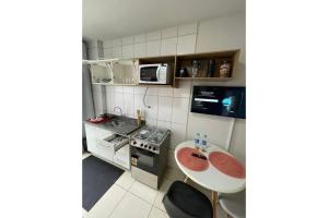 una piccola cucina con tavolo e forno a microonde di Gran Studium a Maringá