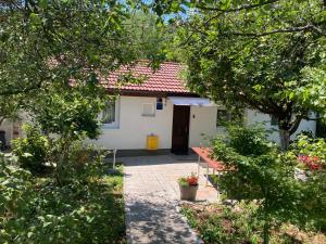 uma pequena casa branca com um telhado vermelho em Mlinovi em Zagreb