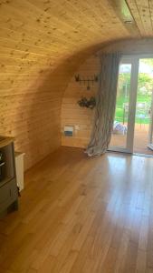 an empty room with wooden walls and a large window at Railway Pod, Castlewellan in Castlewellan