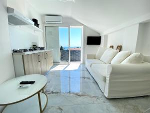 Sala de estar blanca con sofá blanco y mesa en Villa Danza Del Mar - Designed for Adults, en Vir