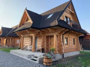a log cabin with a black roof at Pod Brzegiem - Domki góralskie in Czarny Dunajec