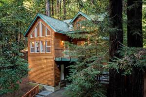 a log cabin in the woods with a balcony at The Wood Chalet Hot Tub BBQ Redwoods in Guerneville