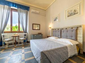 a bedroom with a large bed and a table and chairs at Dimora Altemura in Lucca