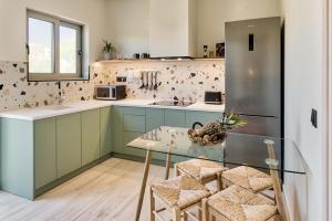 uma cozinha com armários verdes e uma mesa de vidro em Nomas Living em Kalamaki