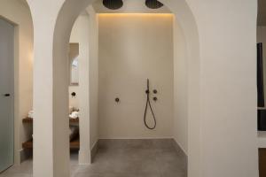 a hallway with white walls and a walk in shower at Polis of Naxos Stylish Suites in Naxos Chora