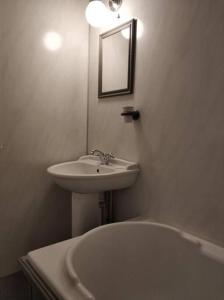 a white bathroom with a sink and a tub at Apartment One Aberystwyth Town Centre in Aberystwyth
