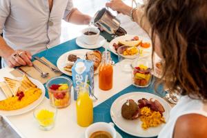 un grupo de personas sentadas en una mesa desayunando en BeYou Hotel Polo, en Riccione