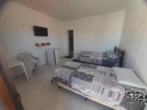 a bedroom with two beds and a television in it at Pousada Progresso in Parnaíba