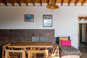 una sala da pranzo con tavolo e sedie in legno di Casa do Cascalho a Ribeira Grande Altre 29 foto