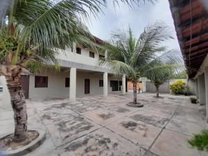 a courtyard with palm trees in front of a building at Pousada Progresso in Parnaíba