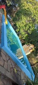 una ventana azul con reflejo de una piscina de agua en Chacara bica dágua en Pirenópolis