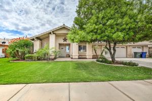 a house with a tree in front of a yard at Sunny Yuma Retreat with Private Pool and Grill! in Yuma