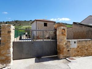 una puerta en un edificio de piedra con una valla en Casa Rural Río Duratón, 