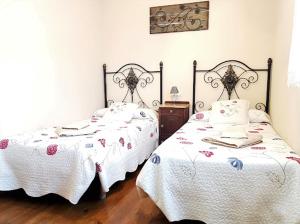 2 camas en un dormitorio con ropa de cama blanca en Casa Rural Río Duratón, 