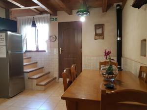 una cocina con mesa y nevera y escaleras en Casa Rural Río Duratón, 