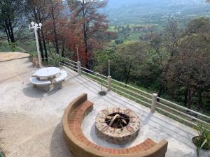 a patio with a fire pit on a hill with trees at Hotel El Mirador y Jardin in Tlayacapan