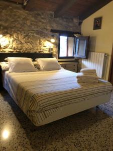 un grande letto in una camera da letto con un muro in pietra di Mas Molladar a Camprodon