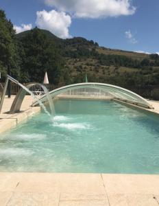 un ponte sopra una piscina con fontana di Mas Molladar a Camprodon