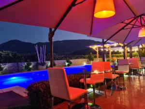 een bar met stoelen en parasols op een patio bij Rossi&Nero Resort - Ristorante, B&B, Piscina, Sauna 