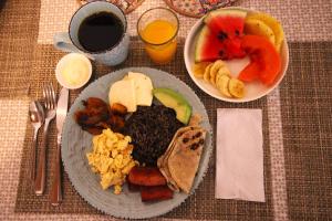 una mesa con un plato de comida y un bol de fruta en F&M Guesthouse en San José