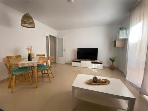 sala de estar con mesa y TV en Topitos Apartment Casc Antic, en Tarragona