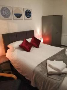a bedroom with a large bed with red pillows at Apartment One Aberystwyth Town Centre in Aberystwyth