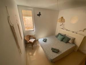 een slaapkamer met een bed, een stoel en een raam bij Topitos Apartment Casc Antic in Tarragona