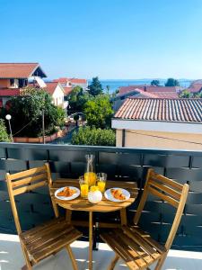 a table with plates of food and drinks on a balcony at Villa Danza Del Mar - Designed for Adults in Vir