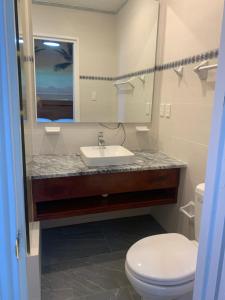 a bathroom with a sink and a toilet and a mirror at Hostal San Lázaro 1103 in Havana