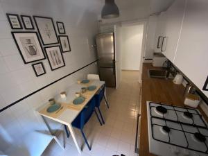 una pequeña cocina con mesa y nevera en Topitos Apartment Casc Antic, en Tarragona