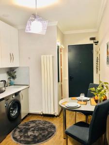 a kitchen with a table and a small kitchen with a dishwasher at Apartment Mari in Tbilisi City