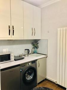 a kitchen with a washing machine and a microwave at Apartment Mari in Tbilisi City