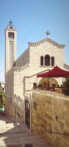 un grande edificio in pietra con torre dell'orologio di Qandeel - Dar Botto a Bethlehem