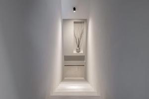 un corridoio con pareti bianche e un vaso sul muro di ANEMA STYLISH RESIDENCE a Città di Zante