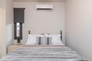 a bedroom with a bed and a air conditioner at ANEMA STYLISH RESIDENCE in Zakynthos