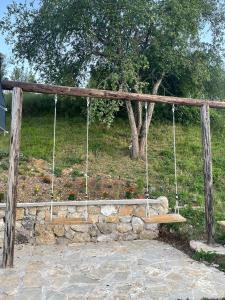a swing in a stone wall with a tree at Brvnara Krin 1 in Nova Varoš