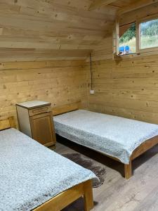 a room with two beds in a wooden cabin at Brvnara Krin 1 in Nova Varoš