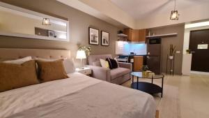 a bedroom with a bed and a living room at The Nook at Serin Tagaytay in Tagaytay