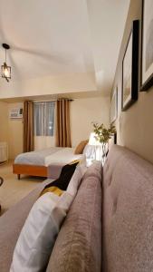 a hotel room with two beds and a couch at The Nook at Serin Tagaytay in Tagaytay