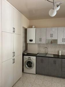 - une cuisine avec des placards blancs et un lave-linge dans l'établissement Hestia, à Gyumri
