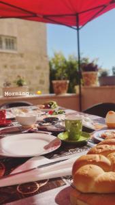 una mesa con platos de comida y una taza de café en Qandeel - Dar Botto, en Bethlehem