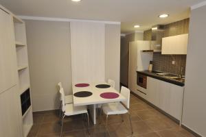 a small kitchen with a table and chairs at Aparthotel Meseguer in Alcañiz