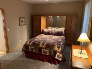 Cozy Riverfront Retreat في ليفنوورث: غرفة نوم بسرير وطاولة مع مصباح