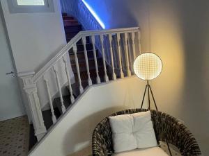 una silla de mimbre sentada bajo una escalera con una escalera blanca en TOP Porto en Oporto