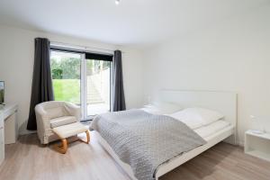 - une chambre avec un lit, une chaise et une fenêtre dans l'établissement Pier 67 Familienkoje Marina Neustadt, à Neustadt in Holstein