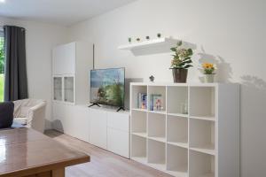 - un salon avec des armoires blanches et une table dans l'établissement Pier 67 Familienkoje Marina Neustadt, à Neustadt in Holstein