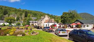 een klein stadje met auto's geparkeerd op een straat bij Stylish Garden Flat Near Loch Ness - Perfect Nessie Stopover in Drumnadrochit