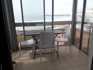- une table et des chaises dans une chambre avec vue sur l'océan dans l'établissement Appartement fonctionnel, vue imprenable mer, à Saint-Gilles-Croix-de-Vie